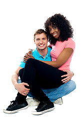 Image showing African teenager sitting on boyfriends lap