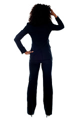 Image showing Rear view portrait of confused businesswoman