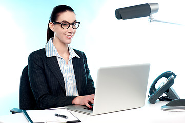 Image showing Smiling female secretary working on laptop