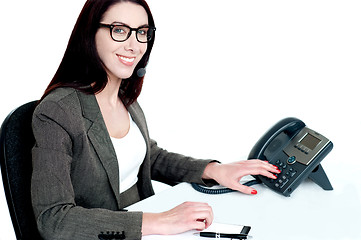 Image showing Attractive female executive dialing clients number