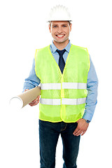 Image showing Smiling young architect holding blueprints