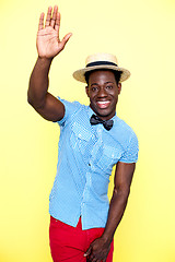 Image showing Casual young african guy posing with raised arm