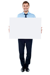 Image showing Businessman holding blank white billboard