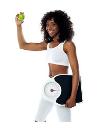 Image showing Athlete holding green apple and weighing machine