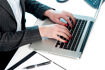 Image showing Females hands typing on laptop keypad. Cropped image