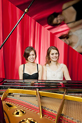 Image showing Pretty girls play two part harmony on a piano