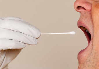 Image showing DNA swab of saliva taken from senior man