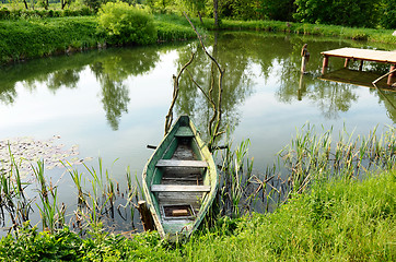 Image showing Old wooden boat stand moored on pond shore bridge 