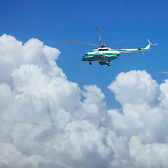 Image showing Helicopter flying above the clouds