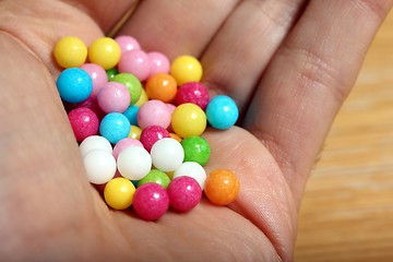 Image showing colored sugar balls in a humand hand