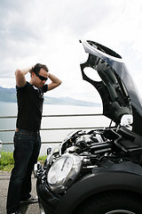 Image showing sad man looking at his broken car 