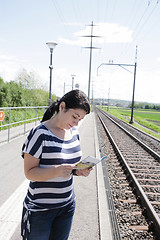 Image showing Young female lost looking the map finding the right direction 