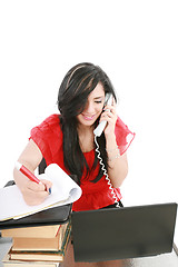 Image showing Smiling young business woman on phone taking notes in office 