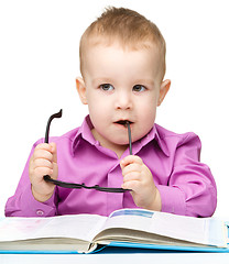 Image showing Cute little child play with book