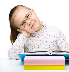 Image showing Cute little girl is tired of reading her book