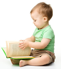 Image showing Cute little boy reads a book