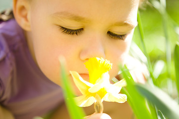 Image showing Portrait of a cute little girl smelling flower