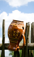 Image showing Clay broken pitcher hang on wooden woven fence 