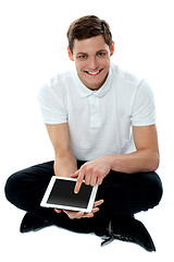 Image showing Seated guy with finger on touch pad device