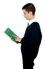 Image showing School boy using big green calculator