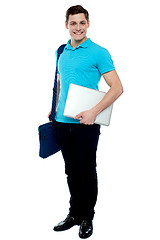 Image showing Cheerful man carrying laptop, off to work