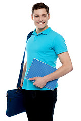 Image showing Smiling guy holding notepad and laptop bag