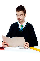 Image showing School boy reading from notebook