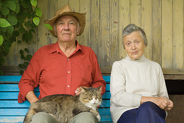 Image showing Older couple with cat sit outdoors