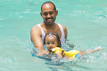 Image showing Teaching baby girl how to swim