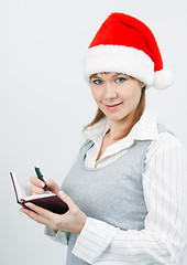 Image showing woman with a notebook in a Christmas hat