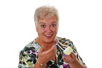 Image showing Senior woman applying lotion on her face