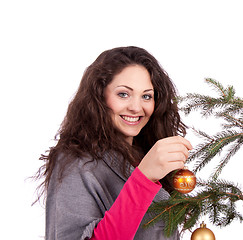 Image showing beautiful brunette woman is decorating a christmas tree 