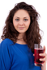 Image showing beautiful smiling brunette woman is drinking red juice