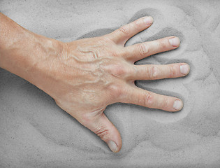 Image showing Man's hand lies on the sand