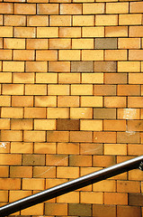 Image showing Background yellow brick wall steel stair railing 