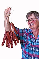 Image showing female butcher with smoked sausage