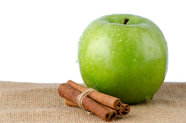 Image showing Ripe green apple with cinnamon sticks