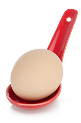 Image showing Brown egg in a red ceramic spoon