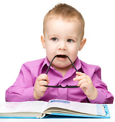 Image showing Cute little child play with book