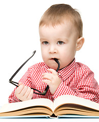 Image showing Cute little child play with book