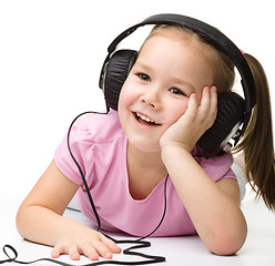 Image showing Cute little girl enjoying music using headphones