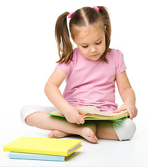 Image showing Cute little girl reads a book