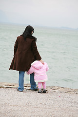 Image showing Mother and daughter looking the sea on winter