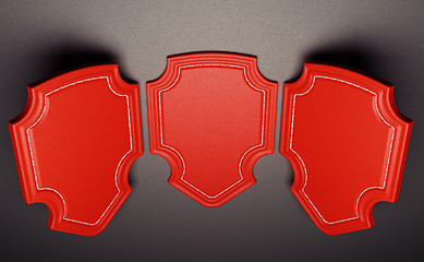 Image showing Three red labels or tags over black leather background