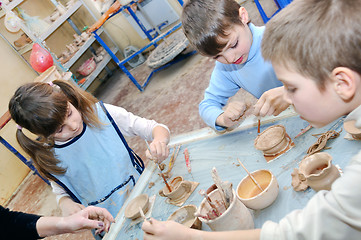Image showing group of children shaping clay in pottery studio