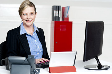 Image showing Cheerful female secretary typing document