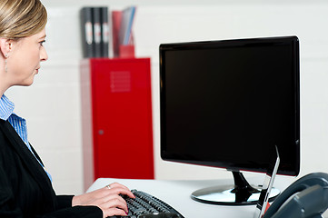 Image showing Female executive typing and looking at lcd screen