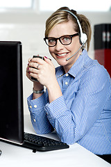 Image showing Help desk executive drinking coffee at work