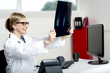 Image showing Female doctor looking at x-ray report of patient