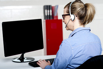 Image showing Back view of help desk lady working